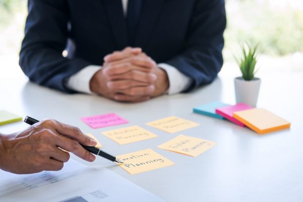 Wealth Management and financial concept, Team of Business accounting analyzing and calculation on valuation data investment fund and looking at report, sticky note paper and having a discussion.